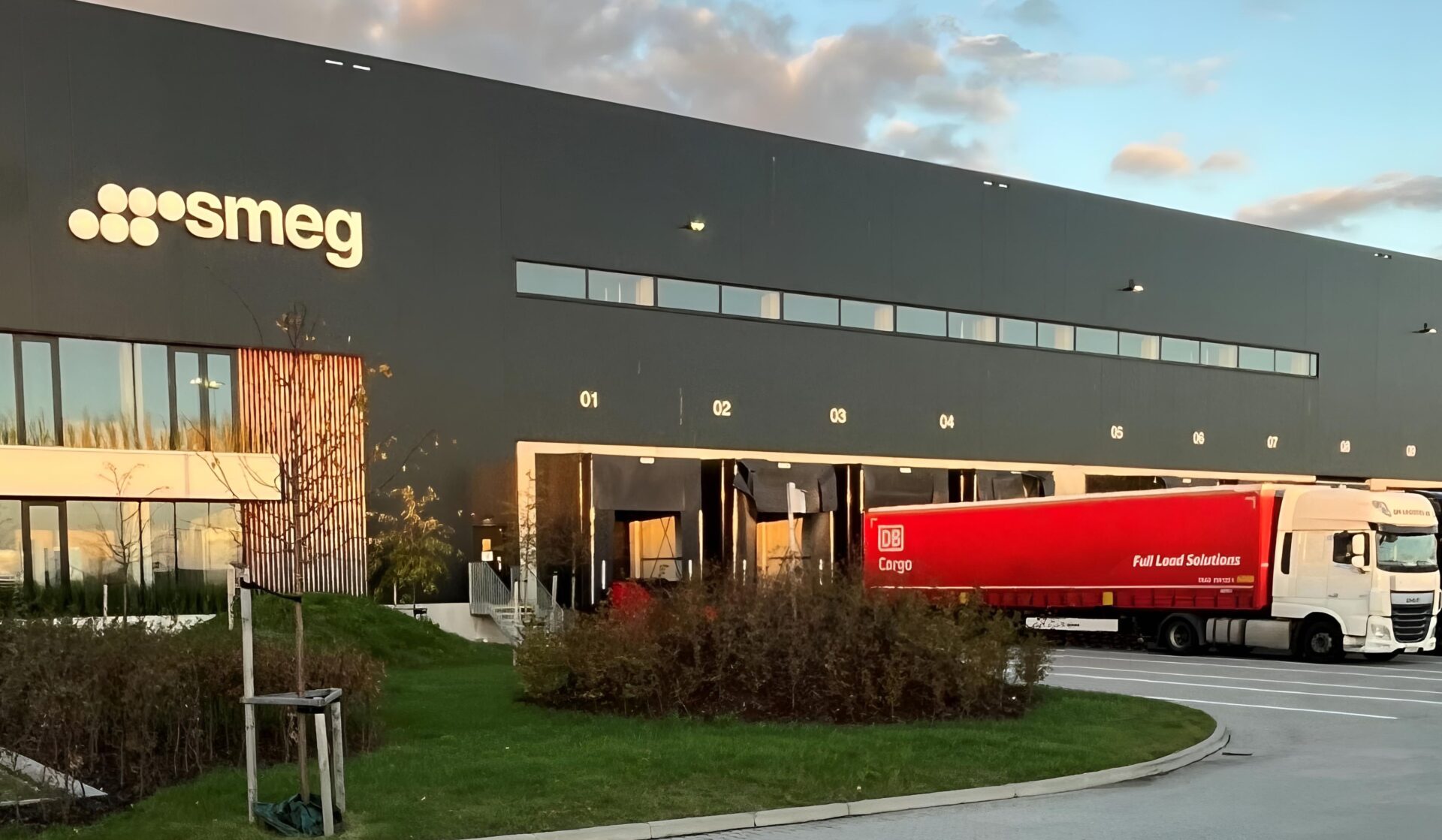     Utanför Smegs lager syns DB Cargo Full Load Solutions röda trailer rulla in med gods för lossning. Godset transporteras via DB Cargo Full Load Solutions intermodala transportlinje mellan Sverige och Italien. 